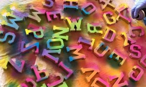 Colourful letters being spray painted on a table